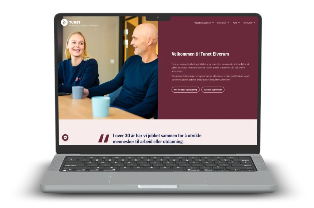 En bærbar skjerm som viser et nettsted med et bilde av to personer som smiler til hverandre. Nettstedets tekst er på norsk, og en del lyder "Velkommen til Tunet Elverum," som fremhever Arbeidsinkluderingsbedriften Tunet Elverums misjon.