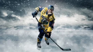 En hockeyspiller i gul og blå uniform skøyter på isen med en hockeykølle, omgitt av flygende snø.